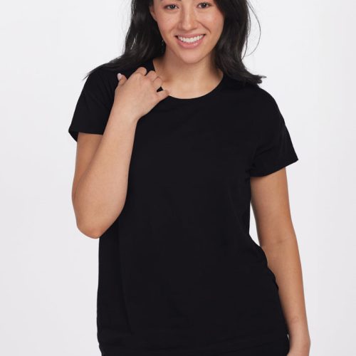 A woman with long, dark hair, wearing the Billie Lounge Tee in black from Woolx designed for moisture-wicking comfort, smiles and poses against a plain white background. | Sarah is 5'8", wearing a size S