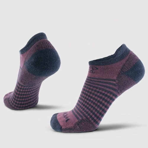 The Amelia No Show Tab Lightweight Socks by Woolx come in a pair, presented on a white background. These socks showcase a checkered pattern in shades of purple and dark blue with solid-colored toes and heels. Made from Merino wool, one sock stands upright while the other leans backward.