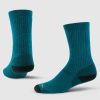 The Woolx Core Crew Sock Full Cushion in Real Teal features two socks made from moisture-wicking Merino wool with dark green reinforced heels and toes. The socks are displayed upright against a plain white background, highlighting their design and texture.