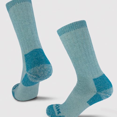 The Woolx Extreme Full Cushion Crew Socks in Real Teal, made from merino wool for exceptional warmth, showcase darker teal accents on the toes, heels, and cuffs. These ribbed socks are elegantly presented against a light gray background.