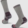 A pair of Windsor Wine Extreme Full Cushion Crew Socks by Woolx, made from merino wool for exceptional warmth, showcases darker gray heels, toes, and cuffs standing upright on a light gray background. One sock is accented with striking red text near the toe area.