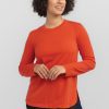 A woman in a Summer Fig Hazel Tunic by Woolx, part of the Stocking Stuffer Final Sale Deals, paired with dark jeans, stands against a light gray background, smiling and looking to the side.