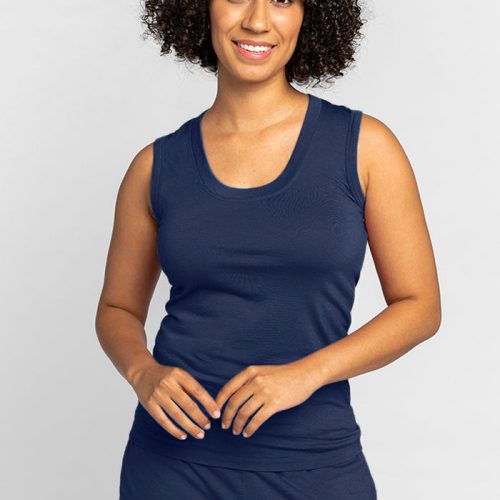 A person with curly hair is smiling and wearing the Phoebe Lounge Tank in Starry Night by Woolx, crafted from moisture-wicking fabric, set against a plain white background. | Tori is 5'7", wearing a size S