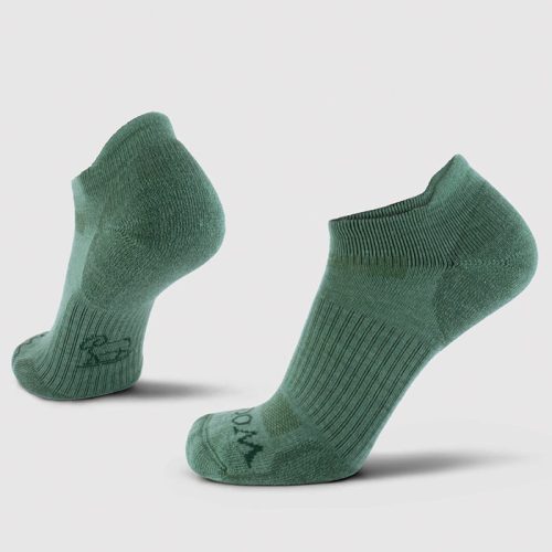 A pair of Rowan No Show Tab Lightweight Socks in Duck Green by Woolx, featuring a ribbed texture. Positioned upright against a light gray background, they showcase their arch support and heel design. The fabric is enhanced with antimicrobial technology and appears soft and stretchy.