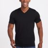 A person smiling, wearing the Ashton V Neck in black by Woolx and blue jeans made from odor-free Woolx DuraLite® Fabric, stands in front of a plain white background.