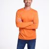 A man with short gray hair and a beard is standing with his arms crossed. He is wearing the Explorer Base Layer - Harvest Pumpkin from Woolx, paired with blue jeans. He is smiling against a plain white background. | Matthew is 6', wearing a size L