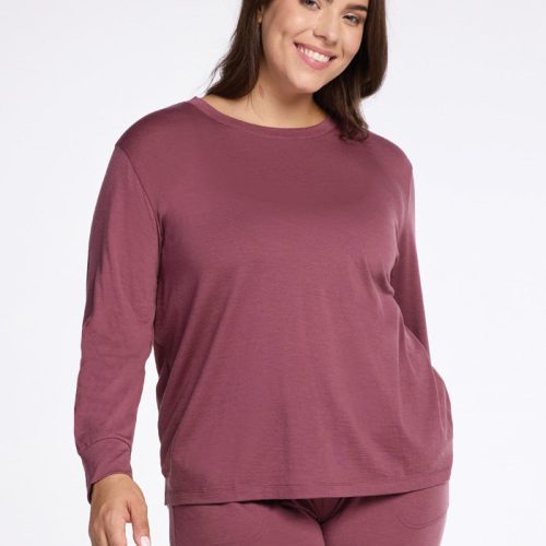 A smiling person wearing the Woolx Ashlie Lounge Top in Wild Ginger stands against a plain white background, paired with matching pants. | Juliana is 5'10", wearing a size XL