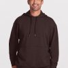 A smiling man with short, gray hair is wearing a Woolx Chase Hoodie in Maple Melange, made of Merino wool, along with blue jeans. He is standing against a plain white background, with his hands by his sides. The men's hoodie features a front pocket and drawstrings. | Matthew is 6', wearing a size L