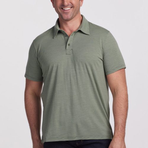 A man wearing a Fern Stripe polo shirt from Woolx and dark jeans smiles while standing against a plain white background. | Brandon is 6’3.5”, wearing a size XL