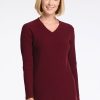 A woman with short blonde hair smiles while wearing the Evie Tunic in Cranberry Melange by Woolx. This cozy, long-sleeved V-neck sweater features a flattering fit as she stands against a plain white background. | Georgia is 5'10", wearing a size XS