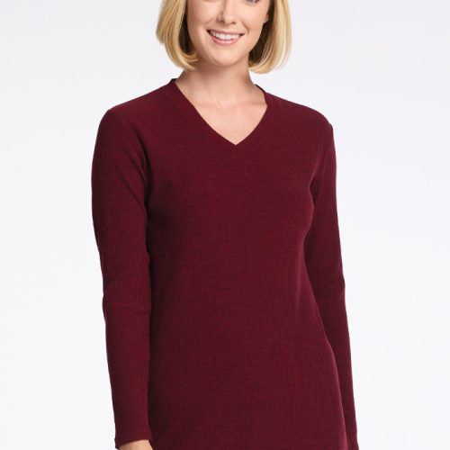 A woman with short blonde hair smiles while wearing the Evie Tunic in Cranberry Melange by Woolx. This cozy, long-sleeved V-neck sweater features a flattering fit as she stands against a plain white background. | Georgia is 5'10", wearing a size XS