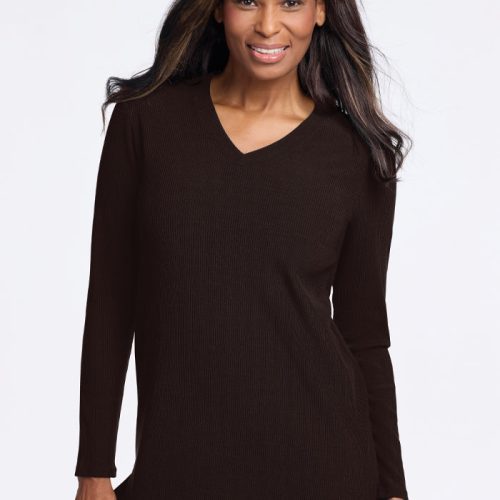 A person with long hair is smiling and wearing a cozy dark Evie Tunic in French Roast from Woolx. The background is plain white, creating a simple and clean composition. | Keesha is 5'9.5", wearing a size S