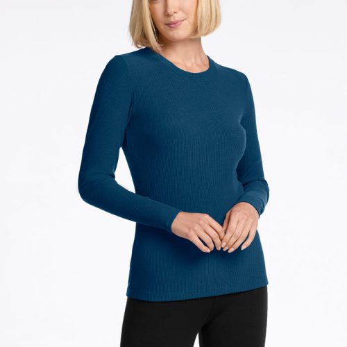 A person with a bob haircut is wearing a Real Teal Hadley Ribbed Crew by Woolx and black pants, standing against a plain white background. The Merino Wool top adds elegance as the person looks to the side with a slight smile. | Georgia is 5'10", wearing a size XS