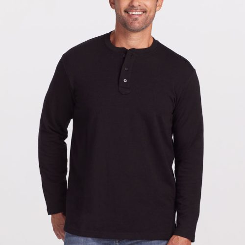 A man with short, dark graying hair and a beard is wearing the Jackson Henley - Black by Woolx, made of Merino wool, along with blue jeans. He is smiling and standing against a plain white background. | Matthew is 6', wearing a size L