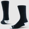 Displayed against a plain light background are two Core Crew Socks Full Cushion - Black by Woolx. Made from Merino wool, these socks feature white toes and heels and are shown at different angles to emphasize their ribbed texture and performance fit.