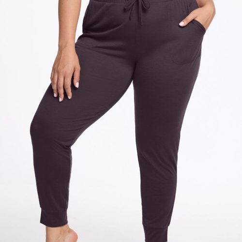 A person stands barefoot against a white background, wearing the Mary Kate Lounge Pants in Chocolate Plum from Woolx. These joggers, crafted from FeatherTouch fabric and excellent for travel lounge wear, feature a drawstring waistband and pockets. They are also wearing a black top.