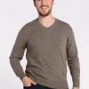 A man with short, brown hair and a beard is smiling while wearing the Sable Vincenzo Sweater by Woolx and dark jeans. He stands against a plain white background with one hand in his pocket. | Will is 6', wearing a size M