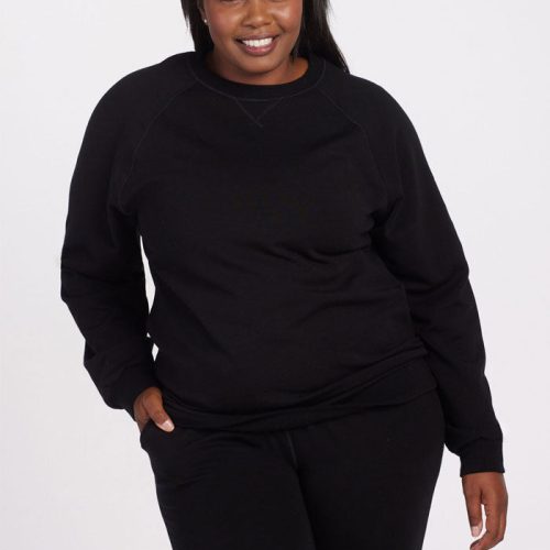 A person smiling while wearing a Woolx Bailey Crewneck Sweatshirt in black, standing against a plain white background. | Le'Quita is 5'11", wearing a size XL