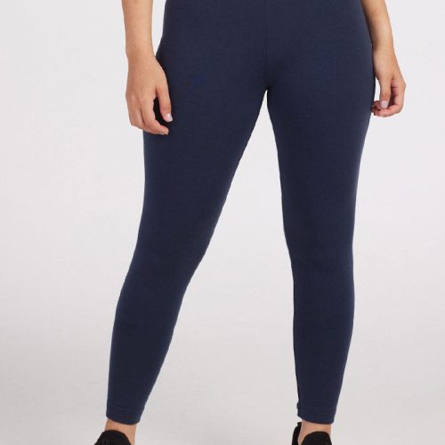 A person wearing Deep Navy Stella Petite leggings and black sneakers stands against a plain white background. The top portion is cropped out, emphasizing the winter wardrobe staple from Woolx, Stella Petite Merino Wool Leggings.