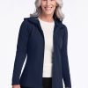 A woman with long gray hair is smiling and standing against a plain background. She is wearing a deep navy Zoey Zip Up Hoodie from Woolx over a light-colored shirt and black pants. | Tam is 5’8.5”, wearing a size S